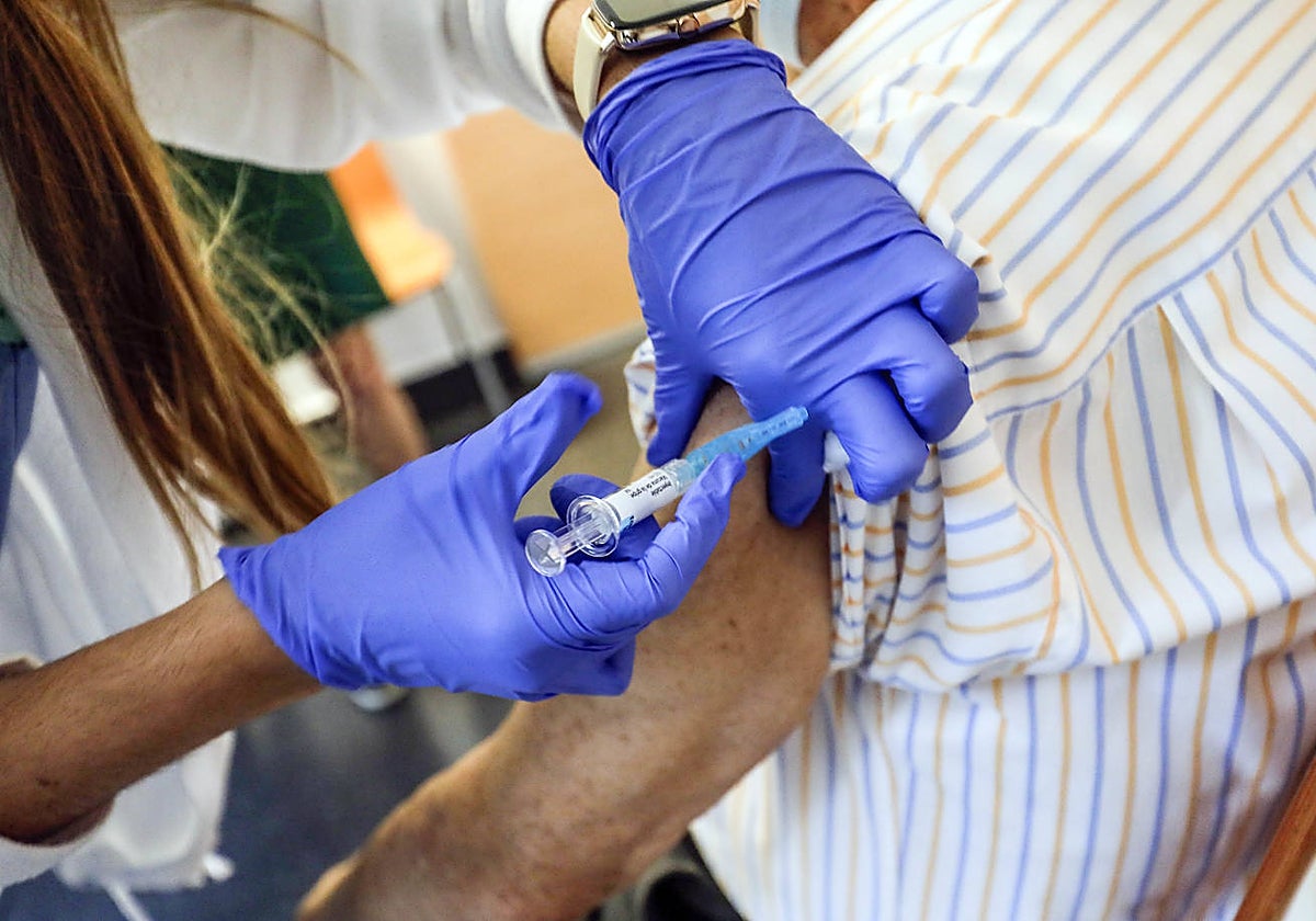 Personal sanitario administra una dosis de la vacuna contra la gripe a un paciente.