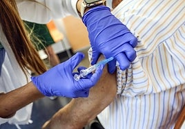 Personal sanitario administra una dosis de la vacuna contra la gripe a un paciente.