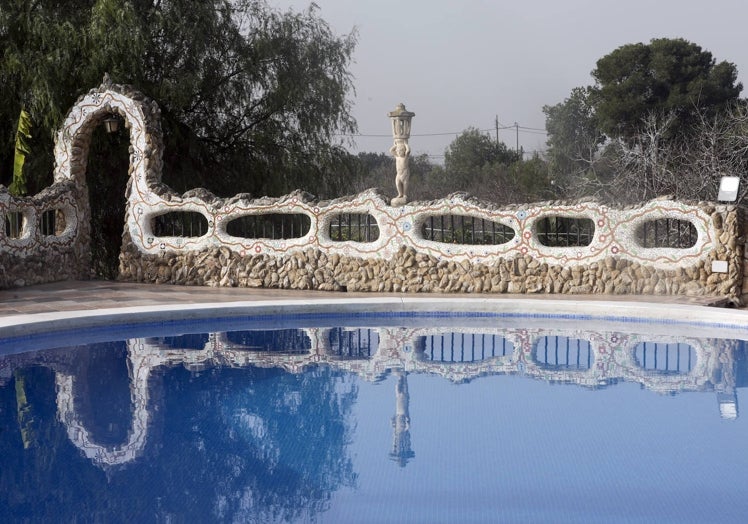 Muro de formas curvas de trencadís con incrustaciones de fósiles marinos, en la piscina de 'La Chacra'.