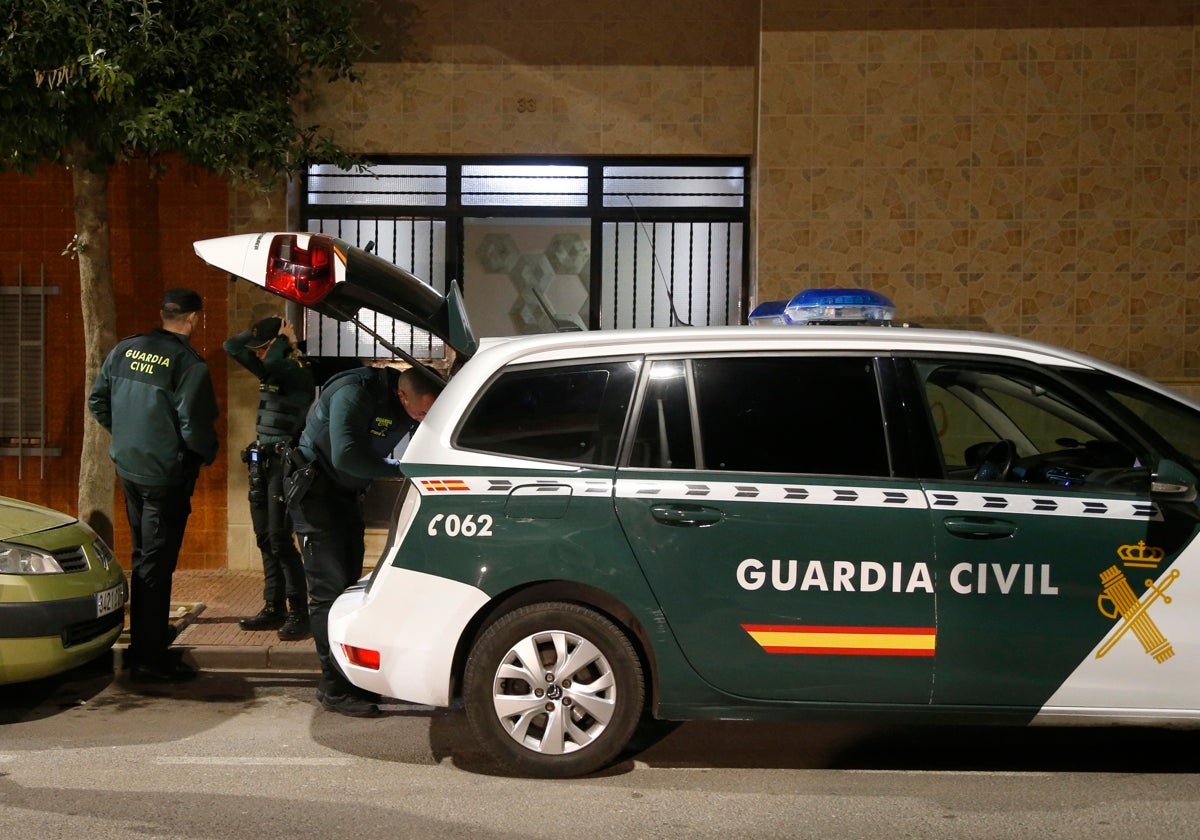 Tres guardias civiles en la puerta del edificio donde tuvo lugar el crimen.