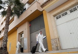 Investigadores, junto a la vivienda donde se produjeron los hechos.