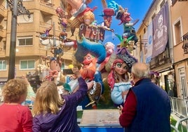 Unos turistas hacen fotos a la Falla Vilanova.