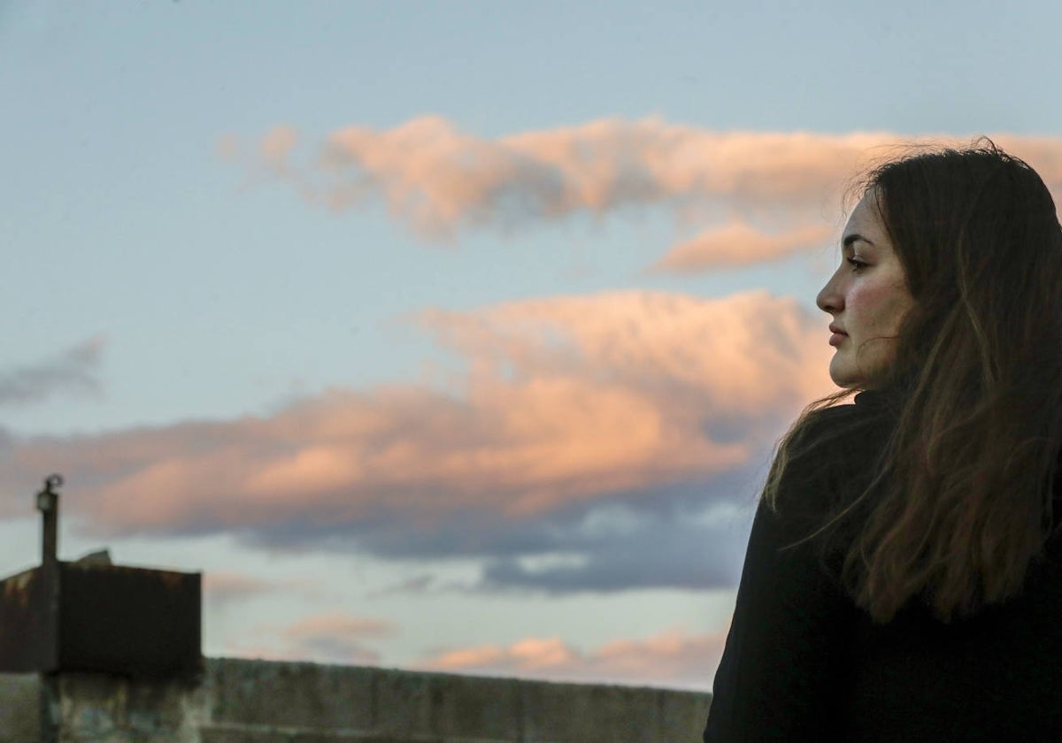 María en la terraza de su casa viendo el atardecer.