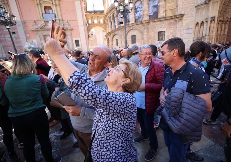 Una mujer se esfuerza por enfocar bien para conseguir la foto.