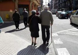 Una pareja de ancianos pasea por la calle. Imagen de archivo