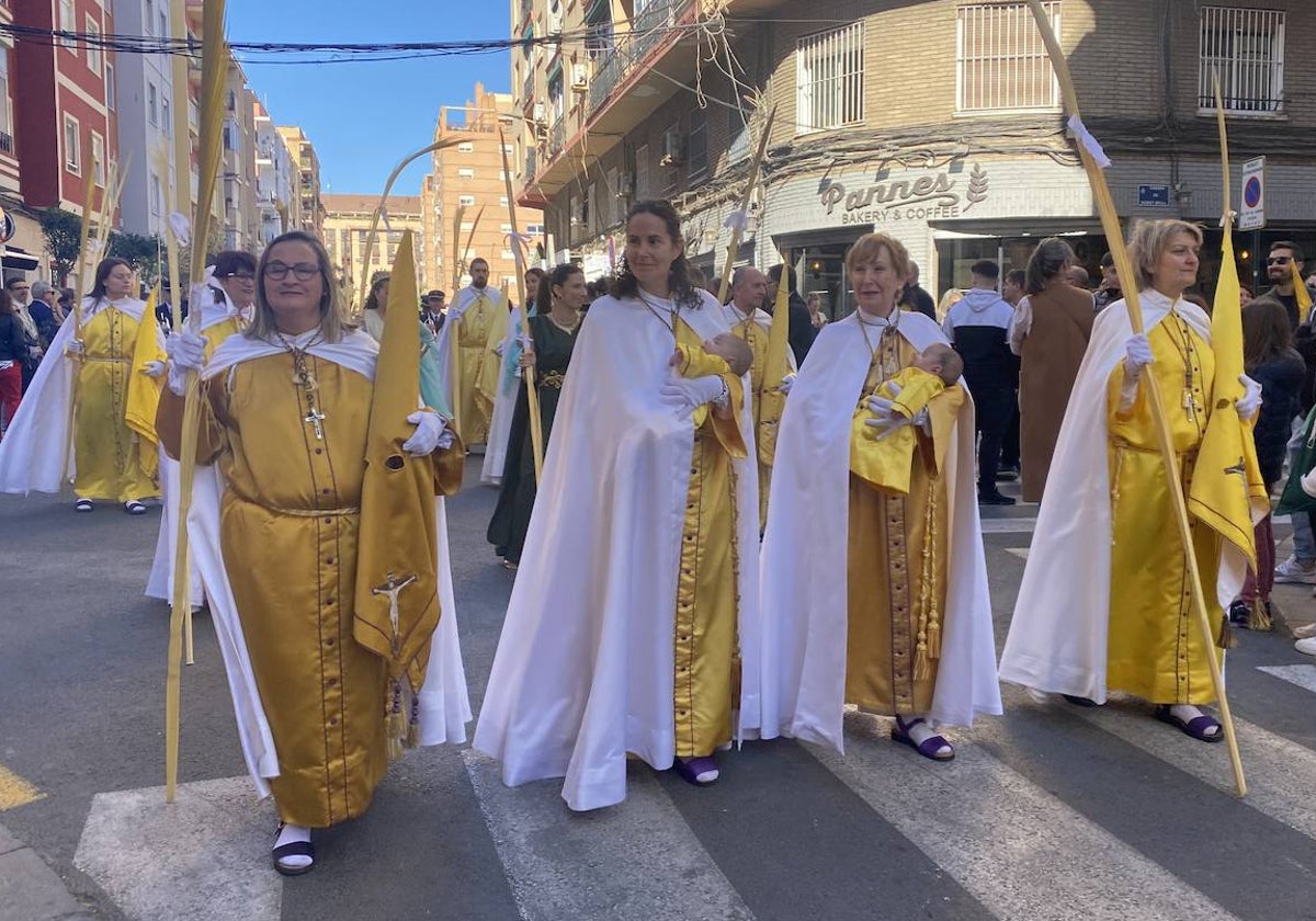 Fila de vestas de la hermandad de los Afligidos integrada por mujeres, con la incorporación de pequeños cofrades.