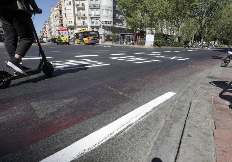 Usuario de un patinete eléctrico, junto al desdibujado carril bici de Gran Vía Fernando El Católico.