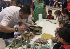 Un chef emplata una elaboración en un colegio público, en una acción para dar a conocer la gastronomía.