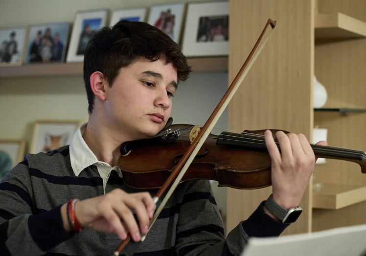 El joven violinista César García ensaya en su casa una pieza de Mozart.