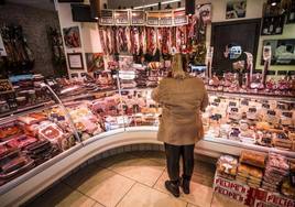 Una mujer junto a un puesto de alimentación.