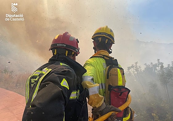 Dos bomberos luchan contra las llamas, el domingo, en el incendio de Oropesa.