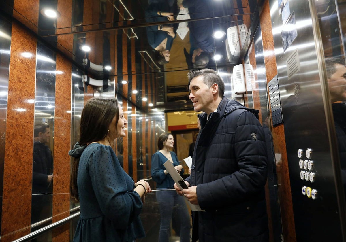 Dos personas conversan en un ascensor de Valencia.