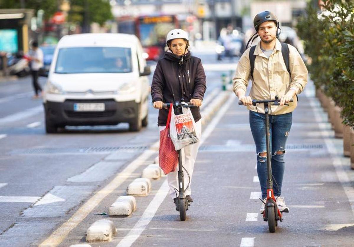 Personas en patinete eléctrico en Valencia.