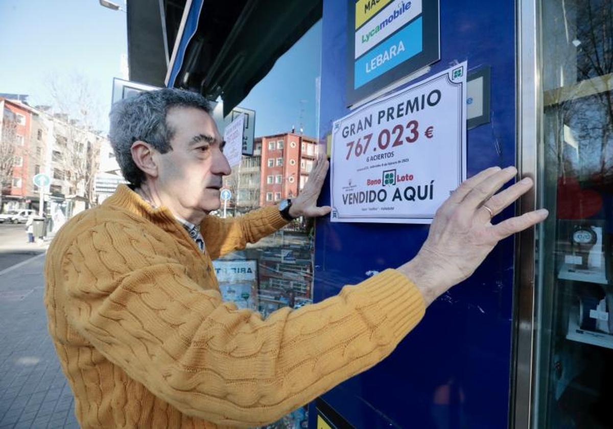 Un lotero cuelga el cartel de un premio de la Bonoloto, en una imagen de archivo.