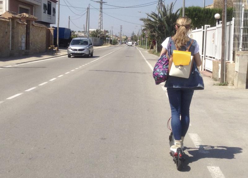 Una joven circula con un patinete en las afueras de Valencia.