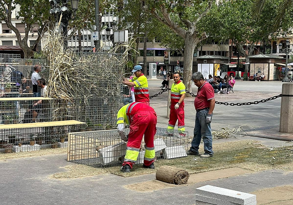 Un grupo de operarios retira los paneles de la plaza del Ayuntamiento de Valencia.