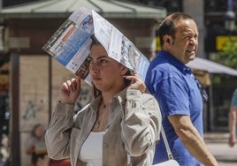 Una joven se protege del calor en Valencia.