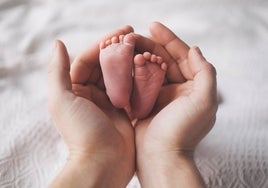 Una madre acariciando a su bebé recién nacido.