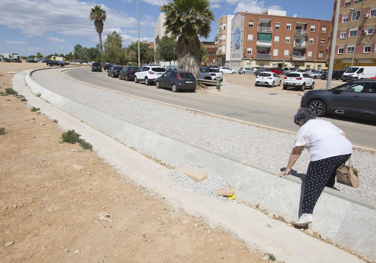 Rosa Rodríguez, sorteando el bordillo que ha puesto el Ayuntamiento en la parte que divide Camí Reial y San Marcelino, para evitar inundaciones.