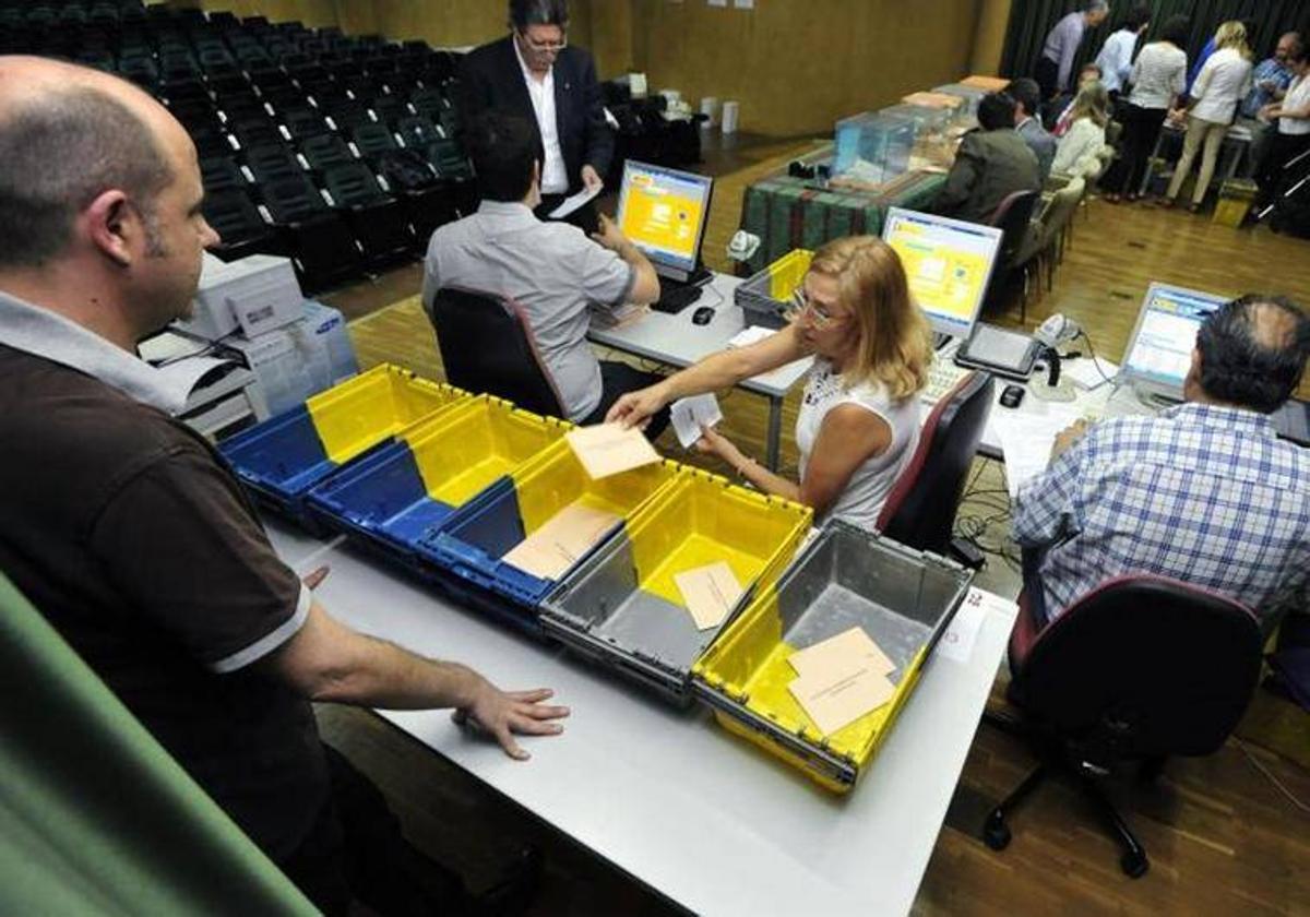 Varias personas contando votos en una imagen de archivo.