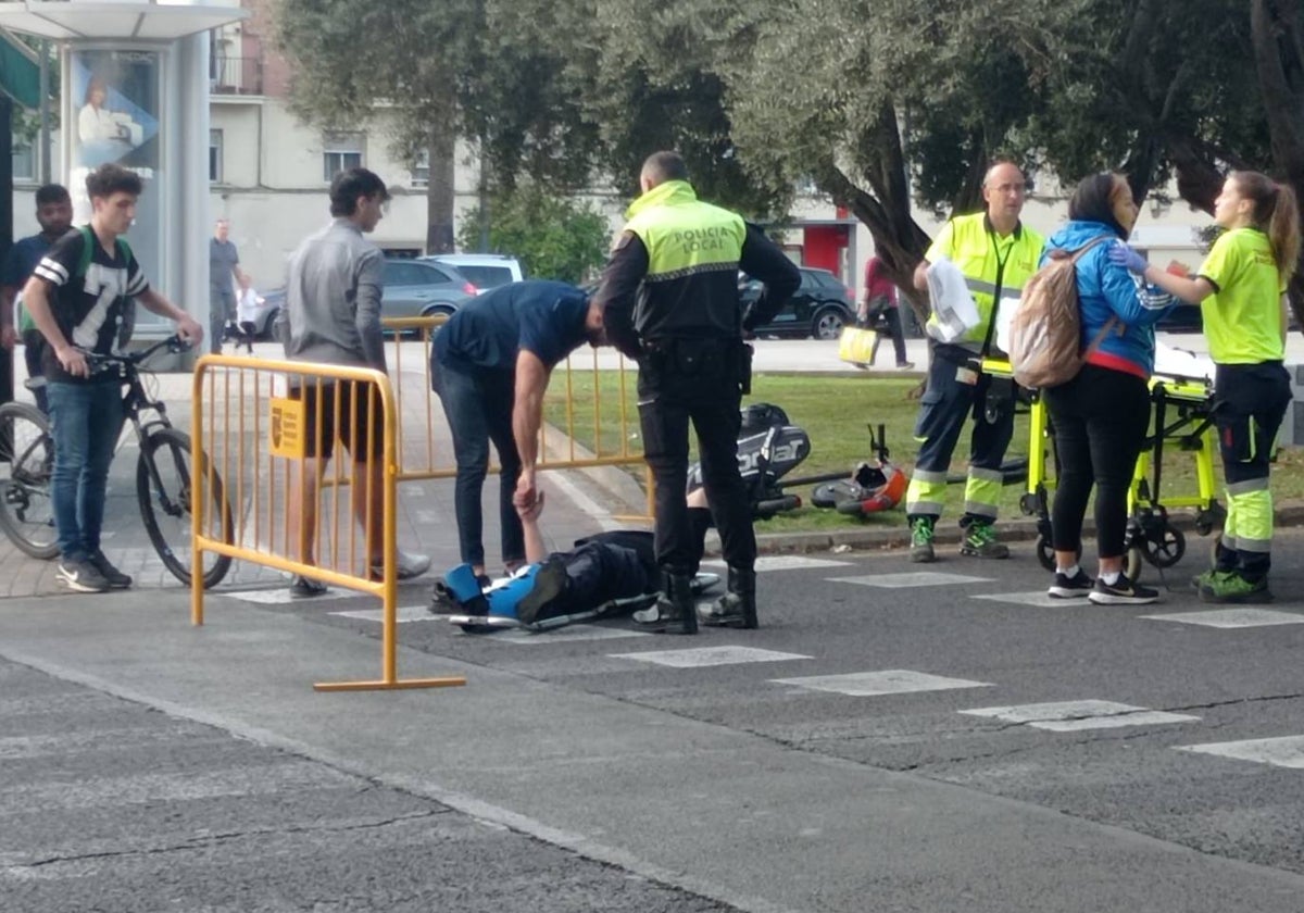 Un agente de la Policía Local y un testigo auxilian a la víctima en el lugar del siniestro, en la Plaza de Zaragoza de Valencia.