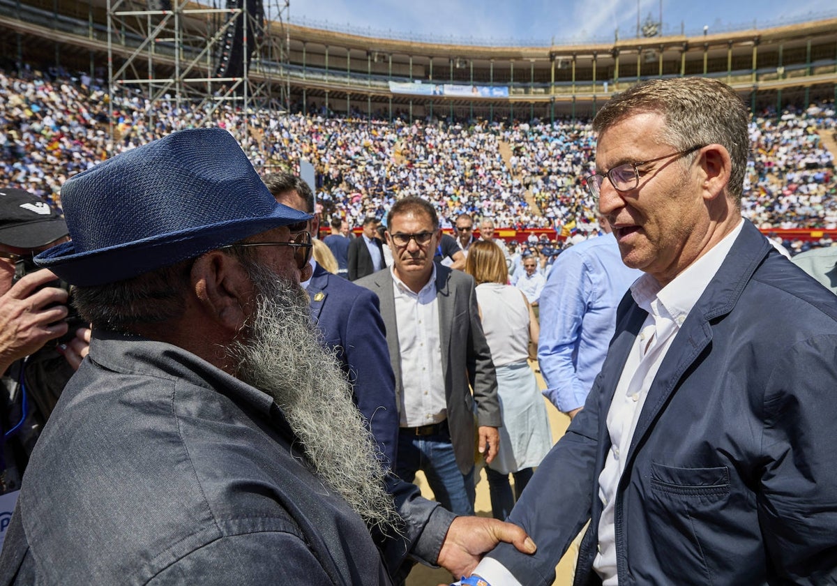 Feijóo saluda a un asistente al mitin, este domingo en la plaza de toros.