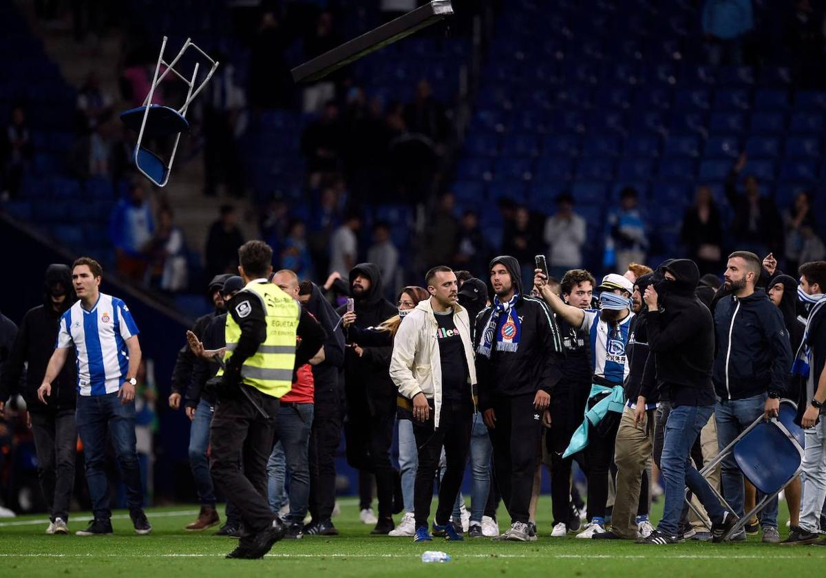 Los ultras del Espanyol, asaltando el césped tras la celebración del Barcelona en su campo.