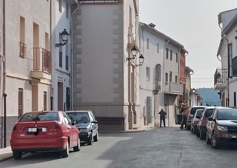 Imagen secundaria 1 - Arriba, el alcalde, en su puesto de trabajo junto a una compañera; en el medio, la plaza del pueblo donde no se ve ningún cartel ni propaganda electoral; sobre estas líneas, uno de los vecinos en la puerta del único bar que hay en el pueblo.