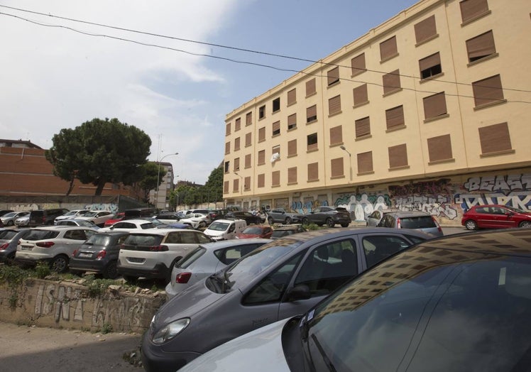 Solares con suciedad y llenos de coches alrededor del edificio.