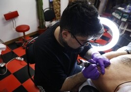 Un tatuador con un cliente en el centro Master Tattoo de Valencia.