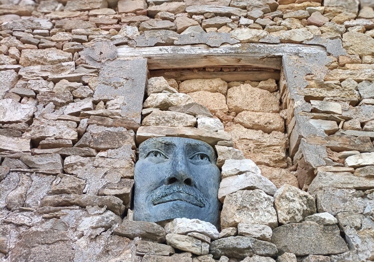 Imagen principal - Una de las caras sobre una fachada de piedra de Diane Gorvin, de su obra Paredes con eco en Arroyo Cerezo. H. E.