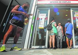 Varias personas haciendo cola frente a una oficina del SEPE.