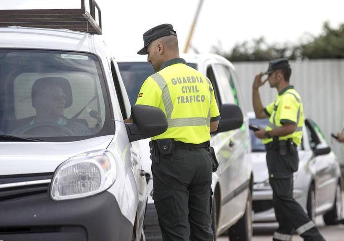 Dos agentes de la Guardia Civil dando el alto a varios vehículos durante un control, imagen de archivo.