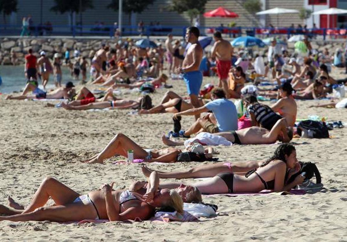 Personas toman el sol en la playa.