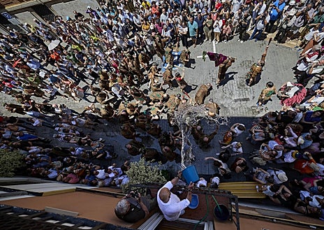 Imagen secundaria 1 - La 'Degollà' recibida con la tradicional 'poalà' de cubos de agua en las calles Cabillers y Avellanas.