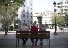 Tres ancianos sentados en un banco. Imagen de archivo