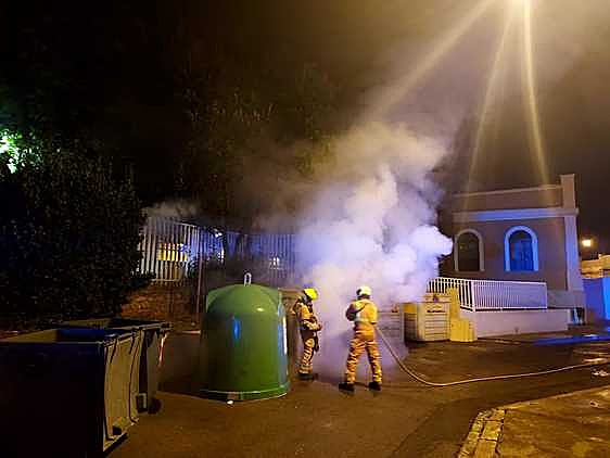 Los bomberos sofocan uno de los fuegos en un contenedor.