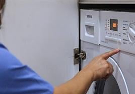 Una mujer pone la lavadora.