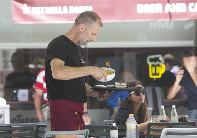 Un camarero con una bandeja en un bar de Valencia.