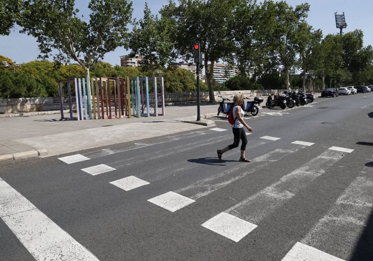 Una mujer atraviesa una marca vial concebida por el reglamento para ciclistas, no para peatones.