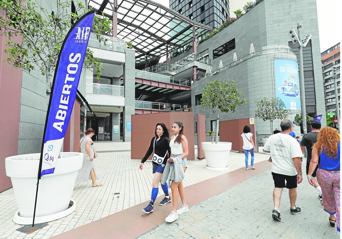 Varias personas caminan por los accesos a un centro comercial de Valencia.