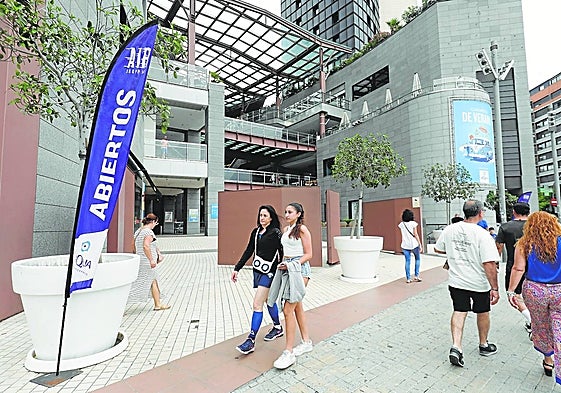 Varias personas caminan por los accesos a un centro comercial de Valencia.