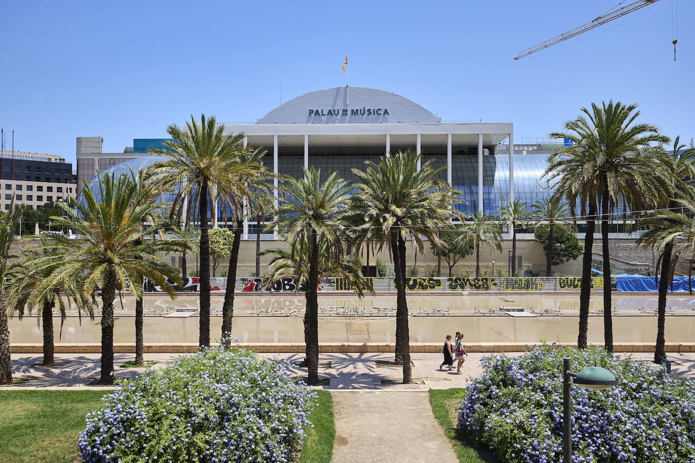 Imagen secundaria 1 - En la imagen superior, la retirada del andamiaje. En la fotografía del centro, el nuevo acristalmiento del vestíbulo. En la tercera imagen, dos operarios trabajan en recuperr el jardín aledaño al Palau de la Música. 