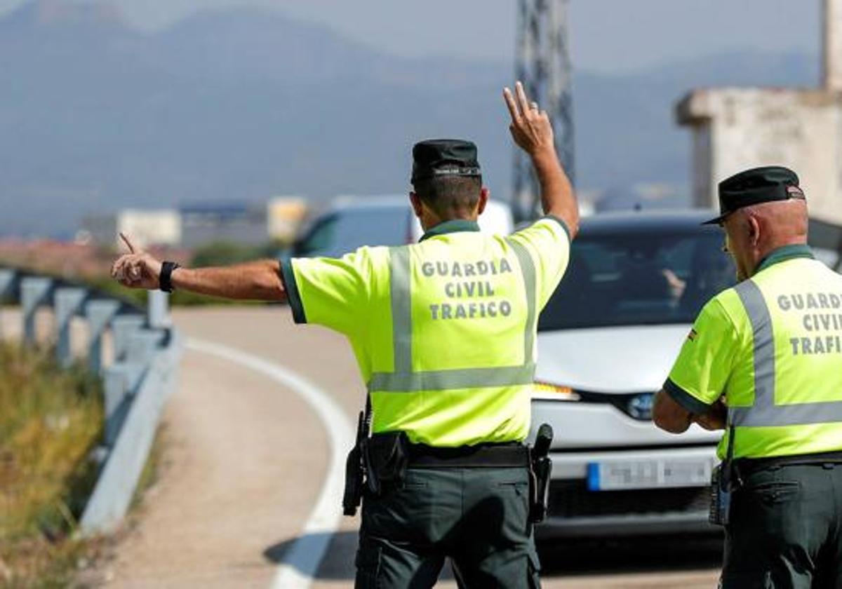 Agentes de la Guardia Civil para a un vehículo.