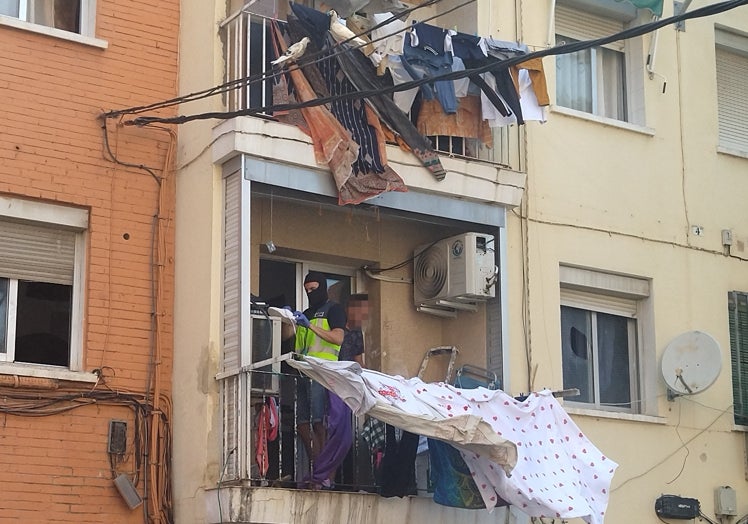 Dos policías registran el balcón de una vivienda.