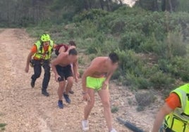 Los tres chicos rescatados antes de subir al helicóptero con los bomberos.