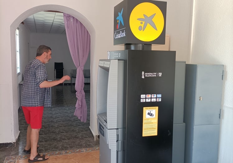 Imagen principal - El único cajero automático que hay en Barbarroja, custodiado bajo llave por uno de los vecinos.