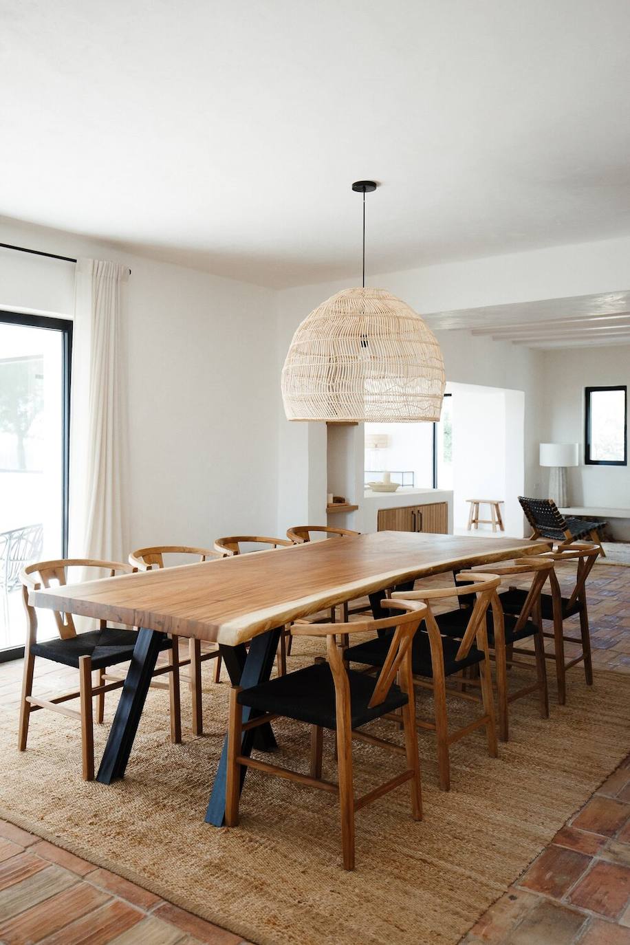 La mesa de comedor es de madera maciza y combinan con una alfombra en materiales naturales.