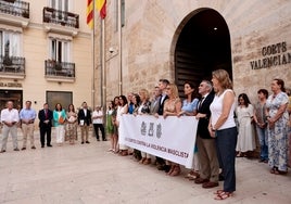 Llanos Massó, junto a otros diputados de Vox, en la parte izquierda. El resto de la Mesa y los portavoces, tras la pancarta.