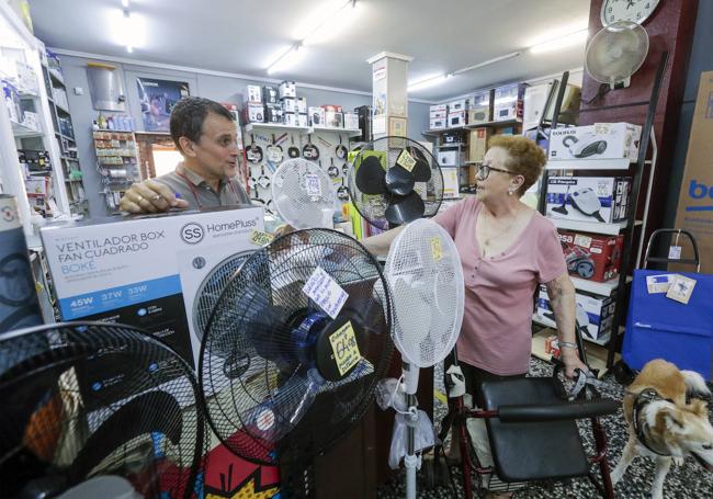 Una mujer se interesa por un ventilador en un comercio de Valencia.